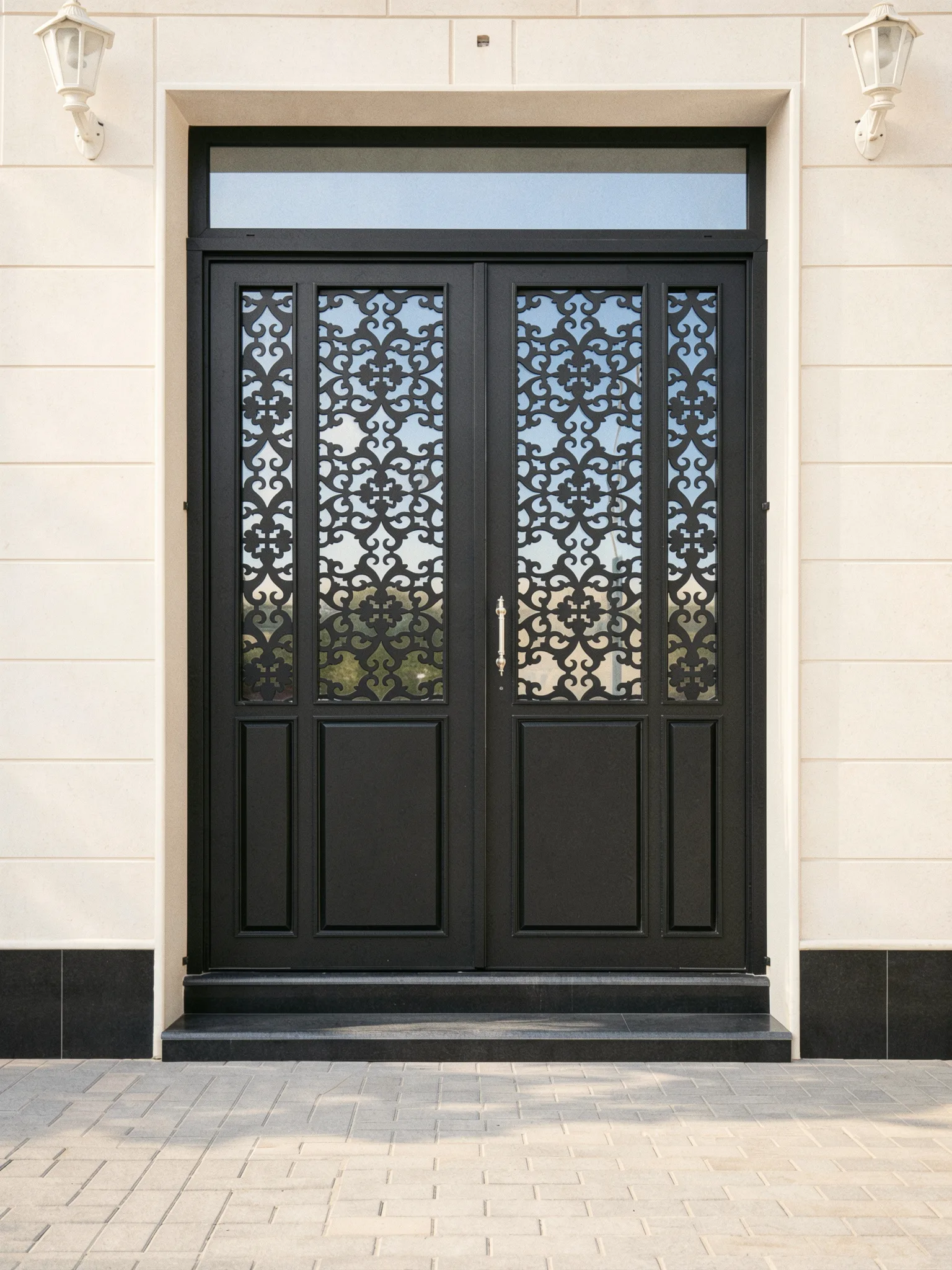 A black double steel door with decorative mashrabiya panels — Front view
