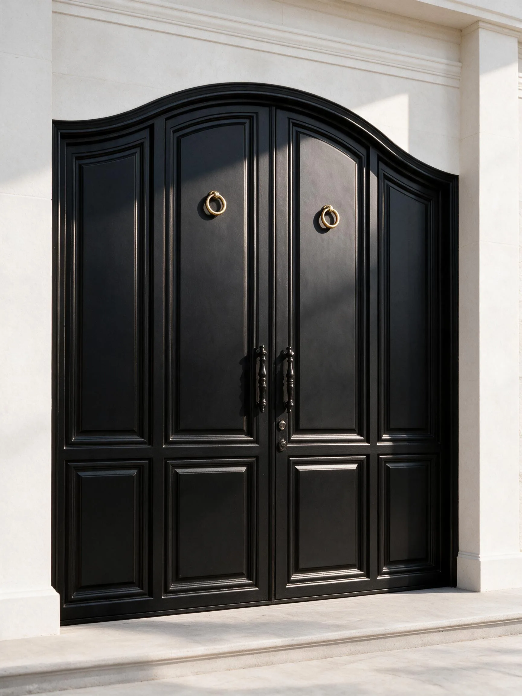 A black double steel door with an arched crown and classical detailing — Front view