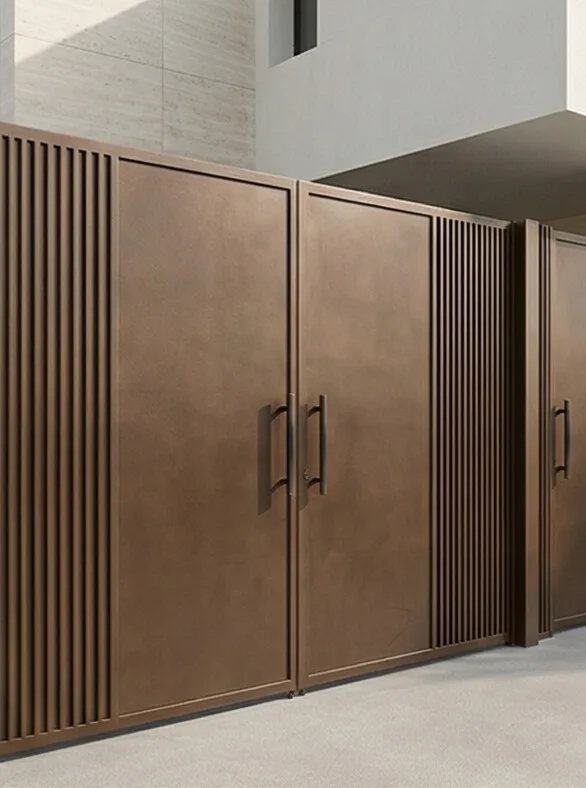 A wide bronze-toned steel gate with vertical linear panels — Side angle